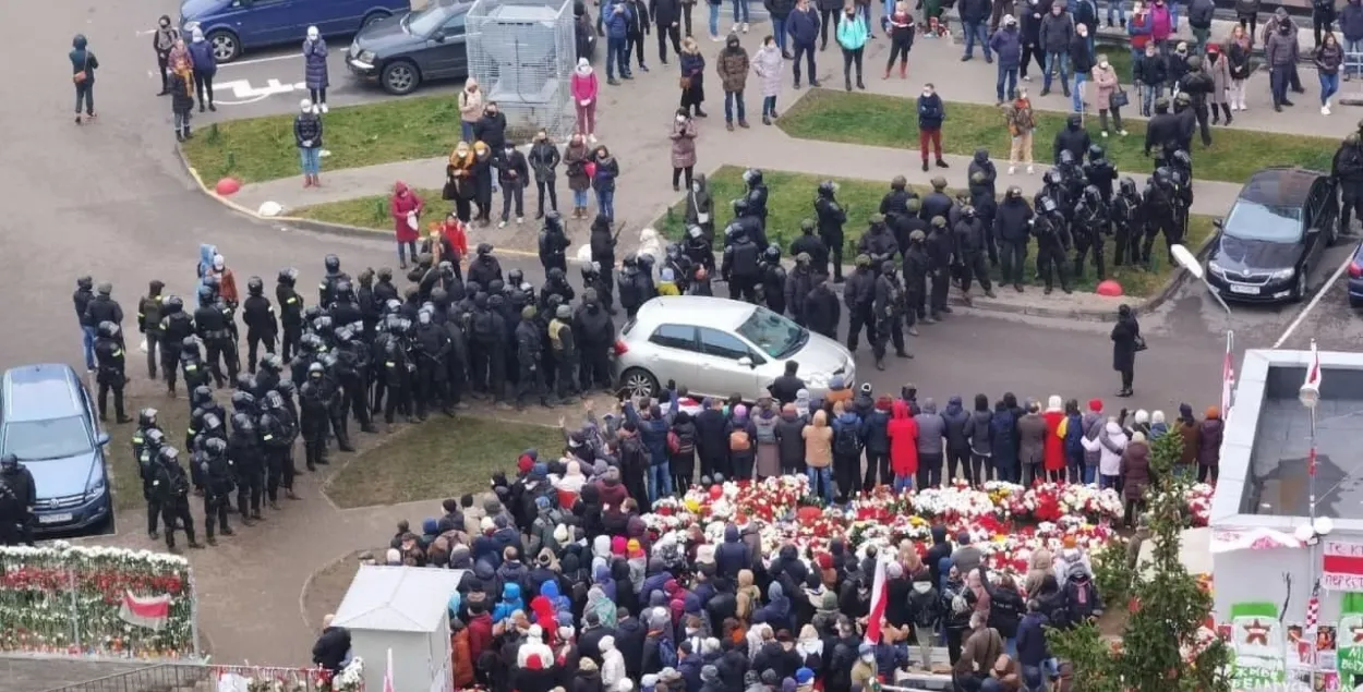 Люди в сцепке охраняют мемориал Роману Бондаренко от силовиков — фото дня