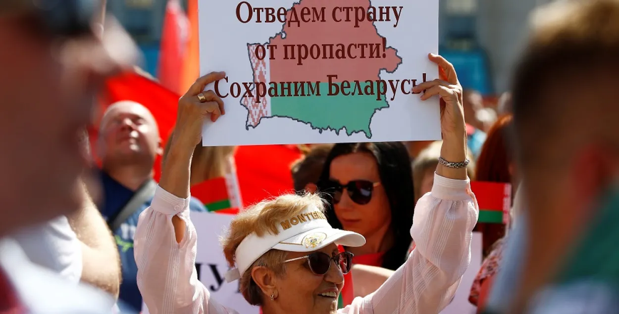 Жанчына трымае плакат на мітынгу ў падтрымку Лукашэнкі 16 жніўня 2020 года Reuters