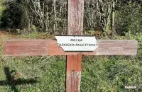 Повреждённая табличка с надписью &rdquo;Место сталинских расстрелов &quot; / racyja.com​