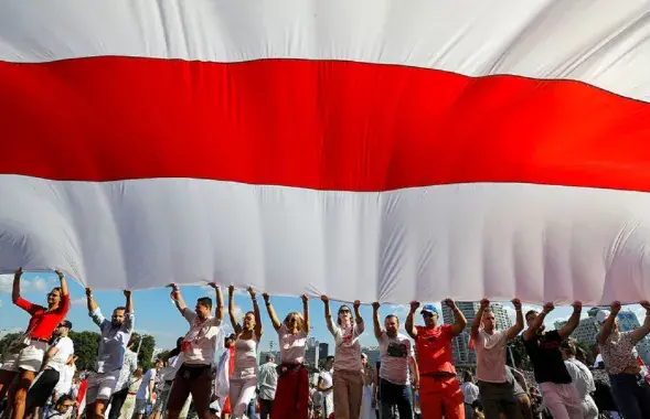Белорусы с огромным бело-красно-белым флагом / АР
