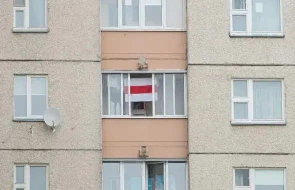 Бело-красно-белый флаг в окне (иллюстративное фото)
