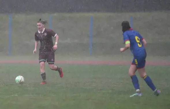 Женский футбол под сильным дождем

